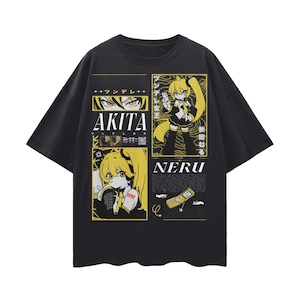 May include: Black t-shirt with a yellow and white anime-style graphic. The graphic features the names "AKITA" and "NERU" with illustrations of anime characters and Japanese text. The design includes a cell phone and other graphic elements.