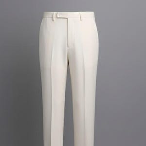 May include: Cream-colored dress pants with a straight leg design. The pants have a waistband with belt loops and a button closure. The fabric appears to be a smooth, woven material. The pants are displayed on a mannequin.