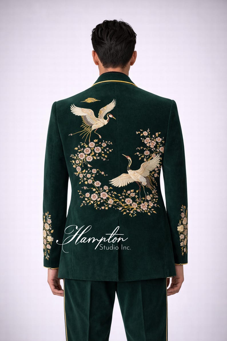 May include: Dark green velvet suit with gold trim and embroidered crane and floral design. The back of the jacket features two cranes with outstretched wings, surrounded by delicate flowers. The suit is from Hampton Studio Inc.