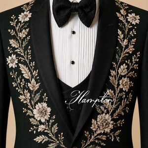 May include: Black tuxedo jacket with floral embroidery in gold and cream. The jacket features a black bow tie, a white dress shirt, and a black vest. The Hampton Studio Inc. logo is visible on the vest.