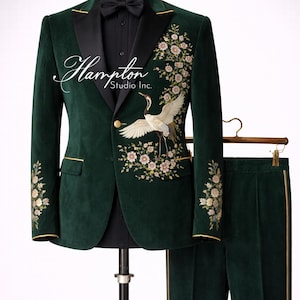 May include: A dark green velvet suit with gold trim, a black lapel, and a black bow tie. The jacket features floral embroidery and a crane design. The suit includes matching pants and the text "Hampton Studio Inc."