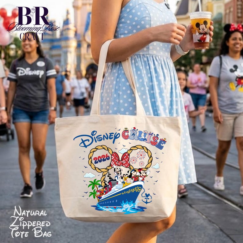 May include: A natural-colored canvas tote bag featuring a Disney Cruise graphic with the text 2026, a cruise ship, and cartoon characters. The design includes rope-style Mickey ears, fireworks, and a red polka-dot bow. The bag has two shoulder straps.