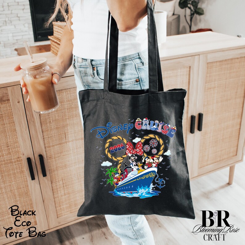 May include: A black tote bag featuring a graphic print of a Disney Cruise ship with characters including Mickey Mouse and Minnie Mouse. The design includes the text Disney Cruise, the year 2026, rope-style Mickey ears, and nautical elements.
