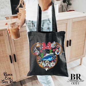 Puede incluir: Un bolso tote negro con un gr&aacute;fico grande de la silueta de la cabeza de Mickey Mouse relleno de personajes de Disney, un crucero, palmeras y elementos n&aacute;uticos como anclas y salvavidas, enmarcado por un borde de cuerda trenzada gruesa.