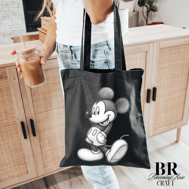 May include: Black tote bag featuring a detailed sketch of Mickey Mouse. The bag has a rectangular shape with two handles. The design is in black and white, with the Blooming Rose Craft logo in the bottom right corner.