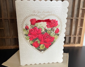 May include: A vintage Valentine's Day card with a white background and a heart-shaped design featuring red roses. The card has a scalloped edge and the text "For You, Sweetheart A Loving Valentine" is printed in gold.