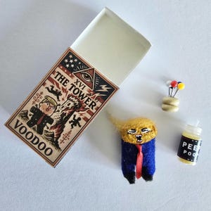 Muñeco vudú de Trump en mini caja de cerillas con alfileres y vela de oración, pequeño hombre naranja en un altar de viaje en una caja de cerillas, presidente vudú FOTUS MAGA Mania