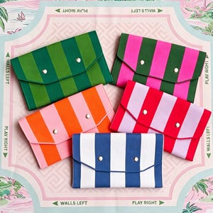 May include: Five rectangular envelope-style clutches featuring vertical stripes in various color combinations: dark green and light green, dark green and pink, orange and light pink, red and light pink, and blue and white, each with two silver snaps.