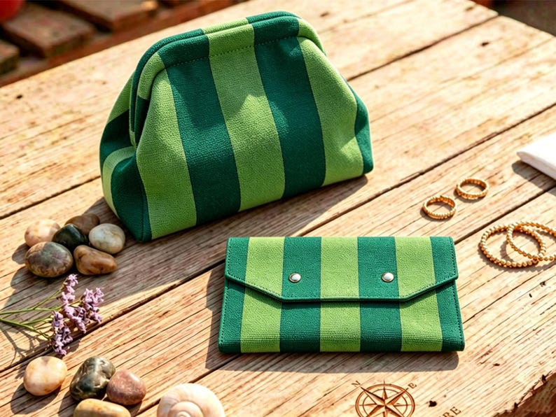 May include: A structured pouch with a kiss-lock closure and a matching rectangular wallet, both featuring a vertical striped pattern in alternating shades of dark forest green and light lime green, crafted from a textured fabric material.