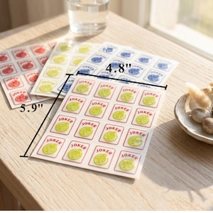May include: Sheets of stickers with a playing card theme. Each sheet is approximately 5.9 inches by 4.8 inches. The stickers feature a joker card design with a green lemon illustration and the word "JOKER".
