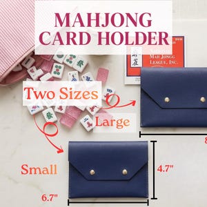 May include: Navy blue Mahjong card holders in two sizes: small (17 cm x 12 cm) and large (21 cm x 14 cm). The holders have a flap closure with gold-coloured snaps. The image also shows Mahjong tiles and a pink striped pouch.
