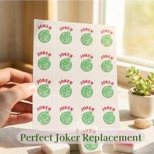 May include: A sheet of white replacement joker tiles with green and red text and graphics. The word "JOKER" is printed on each tile. The text "Perfect Joker Replacement" is at the bottom of the image.