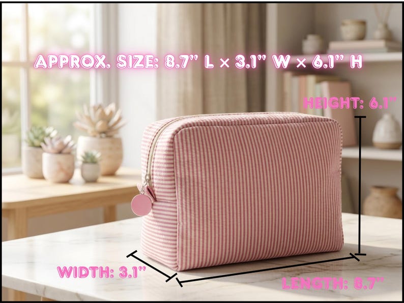 May include: Pink and white striped cosmetic bag, approximately 8.7" long, 3.1" wide, and 6.1" high. The bag has a zipper closure and a small pink charm. The bag is sitting on a white surface.