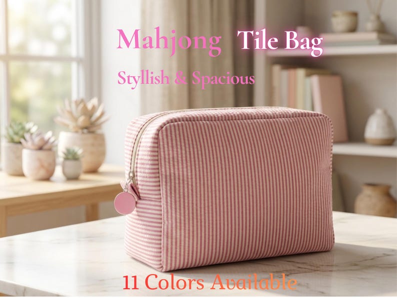 May include: A pink and white striped Mahjong Tile Bag with a zipper closure and a pink charm. The bag is rectangular and sits on a marble surface. Text on the image reads "Mahjong Tile Bag, Stylish & Spacious, 11 Colors Available."