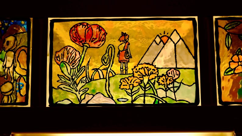 May include: A stained glass panel featuring a landscape scene with a figure, flowers, and mountains. The artwork has a yellow and green background with black outlines. A large red flower is prominent.