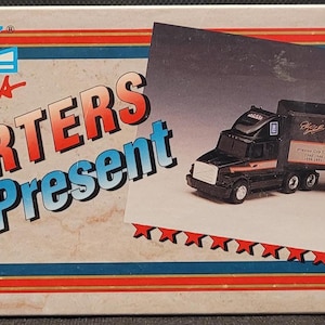 May include: ERTL Racing Transporters Past & Present replica toy truck. The box features a model of a black and brown semi-truck with a trailer. The trailer has the number 3 and the Goodwrench logo. The year 1993 is printed on the box.