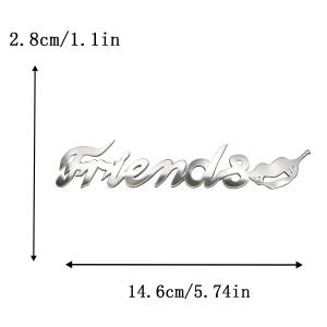 May include: A silver-colored metal emblem with the word "Friends" in a stylized font, accompanied by a lip-shaped design. The emblem measures 5.74 inches wide and 1.1 inches high.