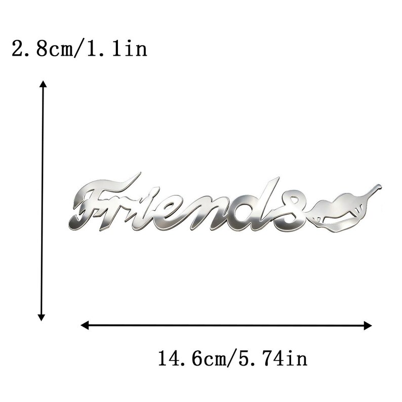 May include: A silver-colored metal emblem with the word "Friends" in a stylized font, accompanied by a lip-shaped design. The emblem measures 5.74 inches wide and 1.1 inches high.