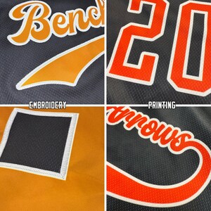 May include: A black and orange mesh jersey fabric featuring embroidered and printed details. The design includes the word Bench in orange script, the number 20 in orange block font, and a black square patch with white stitching on orange fabric.