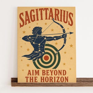 May include: A rectangular poster on a tan background featuring the word SAGITTARIUS in red at the top. A dark blue figure of an archer with constellation lines aims a bow at a green and red target. The text AIM BEYOND THE HORIZON is in red.