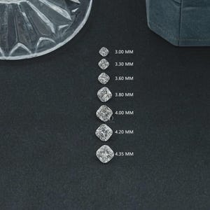 May include: A collection of cushion-cut diamonds of varying sizes, ranging from 3.00 mm to 4.35 mm, displayed on a dark surface. Each diamond is labeled with its millimeter measurement. A clear, decorative glass dish is in the upper left corner.