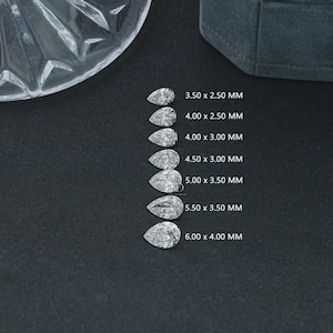 May include: Seven pear-shaped diamonds of varying sizes are arranged on a dark surface. Each diamond is accompanied by its dimensions in millimeters, ranging from 3.50 x 2.50 mm to 6.00 x 4.00 mm. A clear, faceted glass object is visible in the upper left corner.