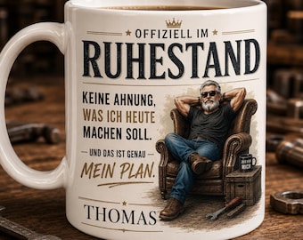 Könnte beinhalten: Weißer Keramikbecher mit Henkel, mit dem Text "OFFIZIELL IM RUHESTAND" und einer Grafik eines Mannes, der sich in einem Sessel entspannt. Zusätzlicher Text enthält "KEINE AHNUNG, WAS ICH HEUTE MACHEN SOLL. - UND DAS IST GENAU - MEIN PLAN." und den Namen "THOMAS."