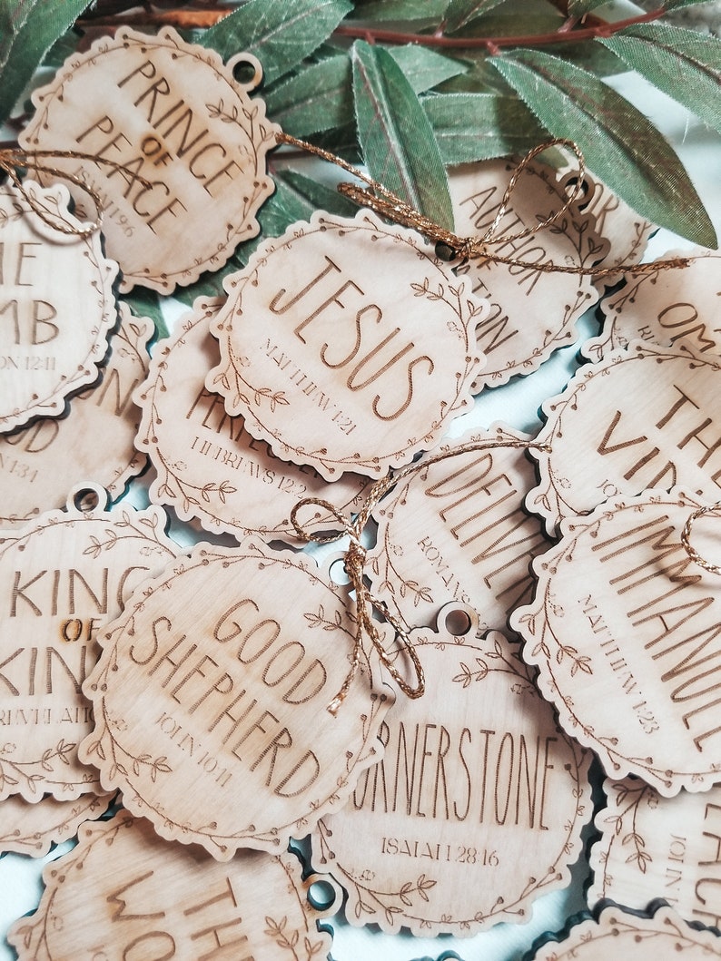 May include: A collection of wooden ornaments with various Christian-themed phrases and scripture verses. The ornaments are decorated with a floral design and have a rustic, natural look.