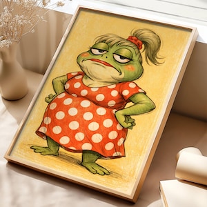 May include: A framed illustration of a grumpy frog wearing a red polka dot dress. The frog has green skin, a red hair tie, and is standing with its arms crossed. The background is yellow.
