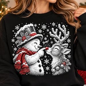 May include: A black crewneck sweatshirt featuring a white graphic of a snowman wearing a top hat and red scarf, touching the red nose of a reindeer. The reindeer wears a collar with bells. The text Boop! is printed between them amidst snowflakes.