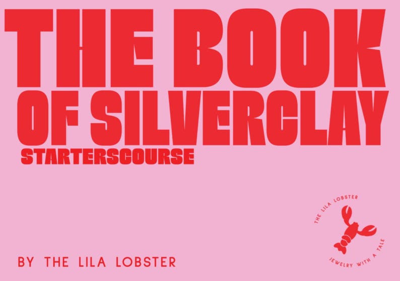 Pu&ograve; includere: Una copertina di libro con sfondo rosa chiaro e testo rosso in grassetto che recita THE BOOK OF SILVERCLAY STARTERSCOURSE BY THE LILA LOBSTER. Nell'angolo in basso a destra, c'&egrave; una piccola icona di aragosta rossa con il testo THE LILA LOBSTER JEWELRY WITH A TALE.