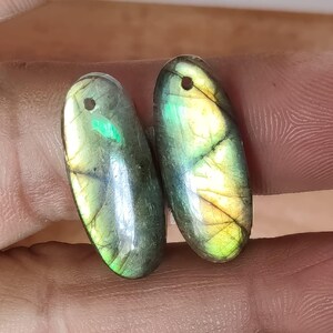 Par de gemas ovaladas de labradorita dorada brillante, perforadas de adelante hacia atrás, 21 quilates.