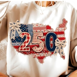 May include: White sweatshirt featuring a patchwork design of the United States map. The map is made of red, white, and blue patterned fabric, with the number "250" in the center. Decorative bows with bird patterns are attached.