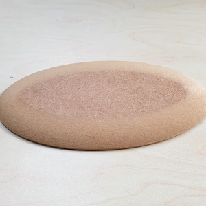 Może przedstawiać: Jasnobrązowy, owalny ceramiczny talerz o teksturowanej powierzchni. Talerz ma lekko podniesiony brzeg i gładkie, nieszkliwione wykończenie. Nadaje się do serwowania potraw.