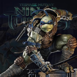 May include: A detailed action figure of Leonardo from Teenage Mutant Ninja Turtles. The figure is in a dynamic pose, holding two katanas. Leonardo is wearing a blue mask and armor, with a green skin tone. The figure is set against a dark background.
