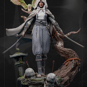 May include: A detailed statue of a warrior figure in a hooded cloak, holding two swords. The figure is in a light gray outfit, with an owl perched on a branch above. The base includes a stone lantern and helmet details.