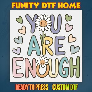 May include: A colorful graphic with the words "YOU ARE ENOUGH" in pastel colors, with daisy accents and heart shapes. The text "READY TO PRESS" and "CUSTOM DTF" are also included.