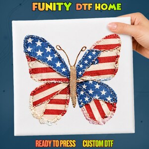 May include: A white square transfer sheet featuring a butterfly graphic with wings patterned like the American flag, displaying red and white stripes and blue sections with white stars. The text FUNITY DTF HOME, READY TO PRESS, CUSTOM DTF is visible.