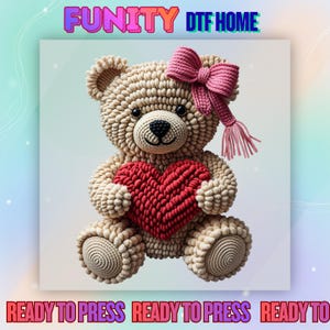 May include: A crocheted teddy bear holding a red heart. The bear is beige with a pink bow and fringe. The text "FUNITY DTF HOME" and "READY TO PRESS" are displayed in the image.
