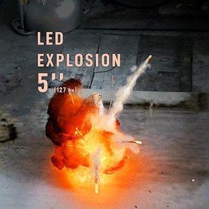 Pu&ograve; includere: Un effetto luminoso a LED a forma di esplosione con un diametro di 127 mm. L'immagine mostra un nucleo luminoso arancione e giallo con raggi di luce bianca che si irradiano verso l'esterno, accompagnato dal testo LED EXPLOSION 5" (127 MM).