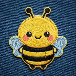 May include: An embroidered patch featuring a cartoon bee with a round yellow head, black eyes, pink cheeks, and a smiling mouth. The body has yellow and black horizontal stripes, two antennae, and light blue wings with white stitching details.
