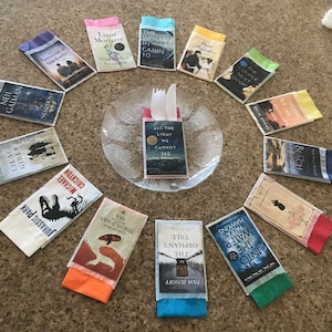 Dodici posate e tovaglioli di Literary Silverware e sacchetti per bomboniere con titoli di libri per adulti/giovani adulti