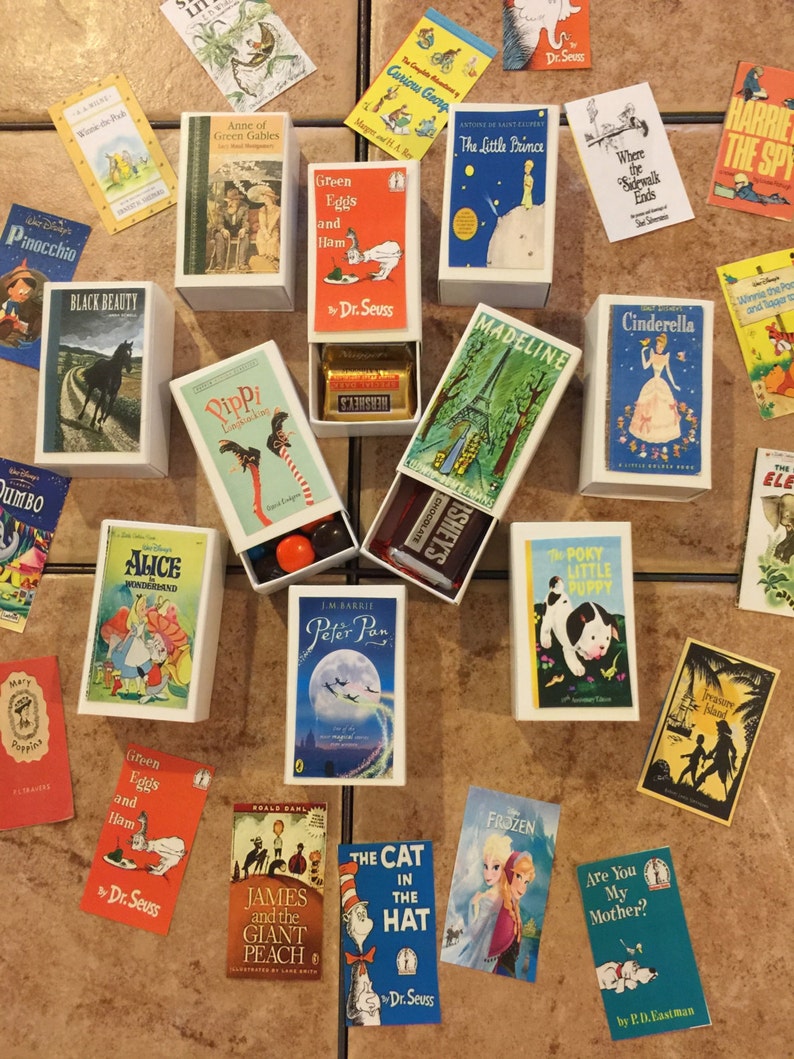 May include: A collection of children's book matchboxes, including classics like 'The Little Prince', 'Madeline', 'Where the Sidewalk Ends', 'Alice in Wonderland', 'Peter Pan', 'Green Eggs and Ham', 'The Cat in the Hat', 'James and the Giant Peach', 'Frozen', 'Are You My Mother?', 'The Portly Little Puppy', 'Treasure Island', 'Winnie the Pooh', 'Black Beauty', 'Pinocchio', 'Dumbo', 'Pippi Longstocking', 'Anne of Green Gables', and 'Curious George'.