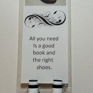 May include: A bookmark with a pair of red sparkly shoes and the text "All you need is a good book and the right shoes."