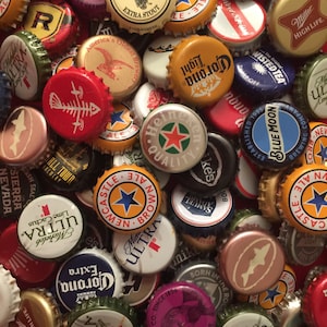 May include: A collection of colorful bottle caps from various beer brands, including Miller High Life, Corona, Blue Moon, and Sierra Nevada. The caps are arranged in a random pattern, creating a visually appealing collage.