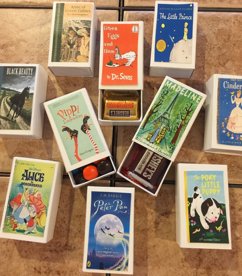 May include: A collection of miniature matchbox-sized books with candy inside. The books include titles like "Anne of Green Gables", "Green Eggs and Ham", "The Little Prince", "Black Beauty", "Pippi Longstocking", "Alice in Wonderland", "Peter Pan", "Madeline", "Cinderella", and "The Poky Little Puppy".