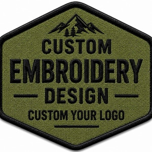May include: A hexagonal olive green patch with a black embroidered border. The patch features a black mountain and tree graphic at the top, with the text CUSTOM EMBROIDERY DESIGN and CUSTOM YOUR LOGO stitched in black thread across the center.
