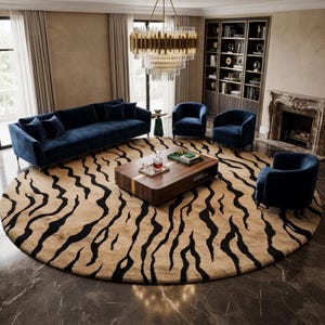 Puede incluir: Una alfombra redonda grande con una base de color beige y un patrón de rayas de tigre negras. La alfombra está situada en una sala de estar con un sofá largo azul, tres sillones azules, una mesa de centro de madera y una lámpara dorada.
