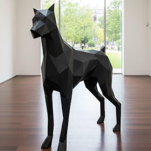 Puede incluir: Una gran escultura geométrica de un perro negro. La obra de arte está hecha de muchos planos triangulares planos, lo que le da una apariencia facetada. El perro está de pie sobre un suelo de madera en una habitación con una gran ventana.