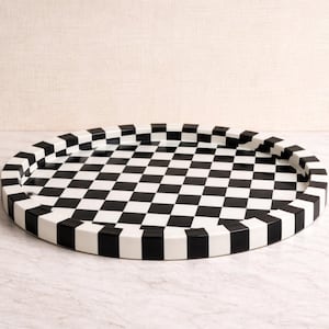 May include: An oval serving tray with a black and white checkered pattern. The tray's rim is also black and white, creating a cohesive design. The tray is approximately 18 inches in diameter.